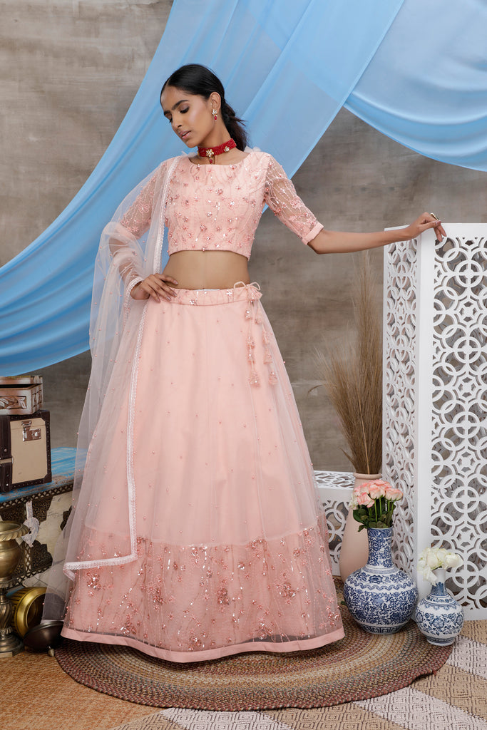 Peach Thread And Sequence Embroidered With All Over Pearl Rivet Stud Pasting Net Semi Stitched Bridal Lehenga ClothsVilla
