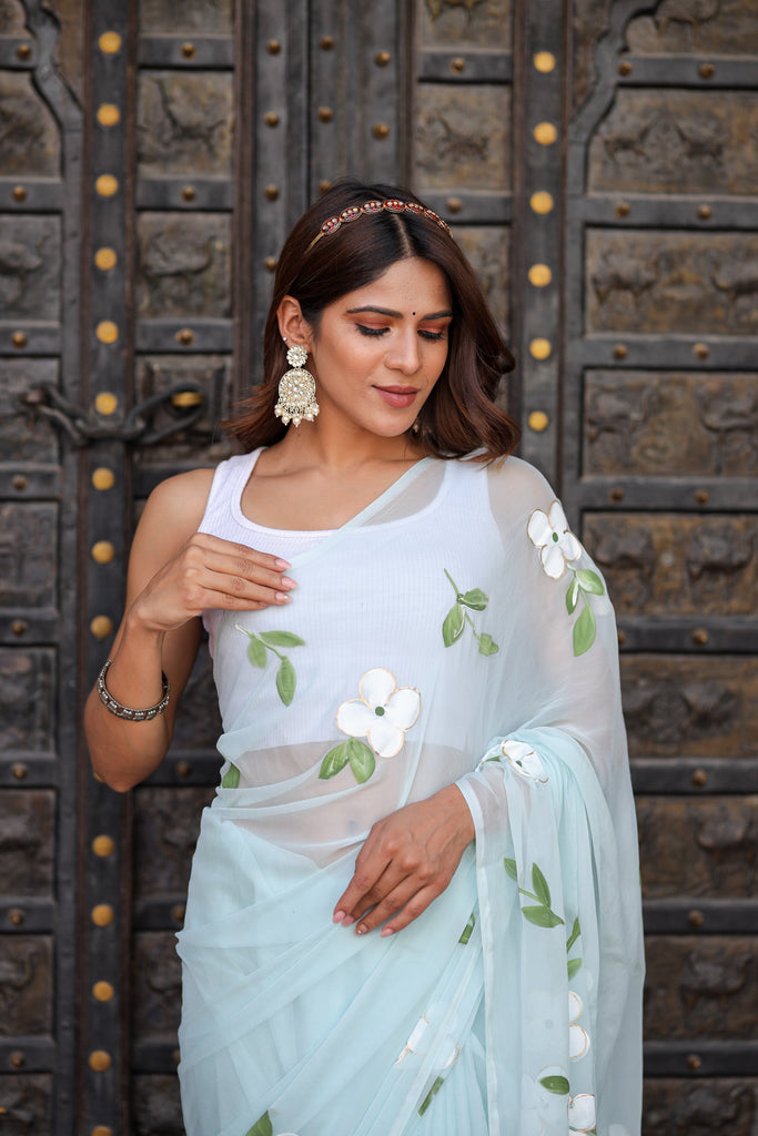 Pastel Blue Georgette Saree with Hand-Painted White Floral Motifs & Green Leaves – Attached Blouse – 5.5 Meters FANCY SAREES