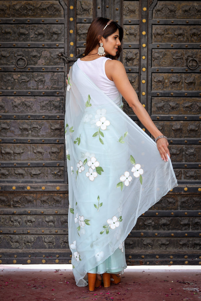 Pastel Blue Georgette Saree with Hand-Painted White Floral Motifs & Green Leaves – Attached Blouse – 5.5 Meters FANCY SAREES