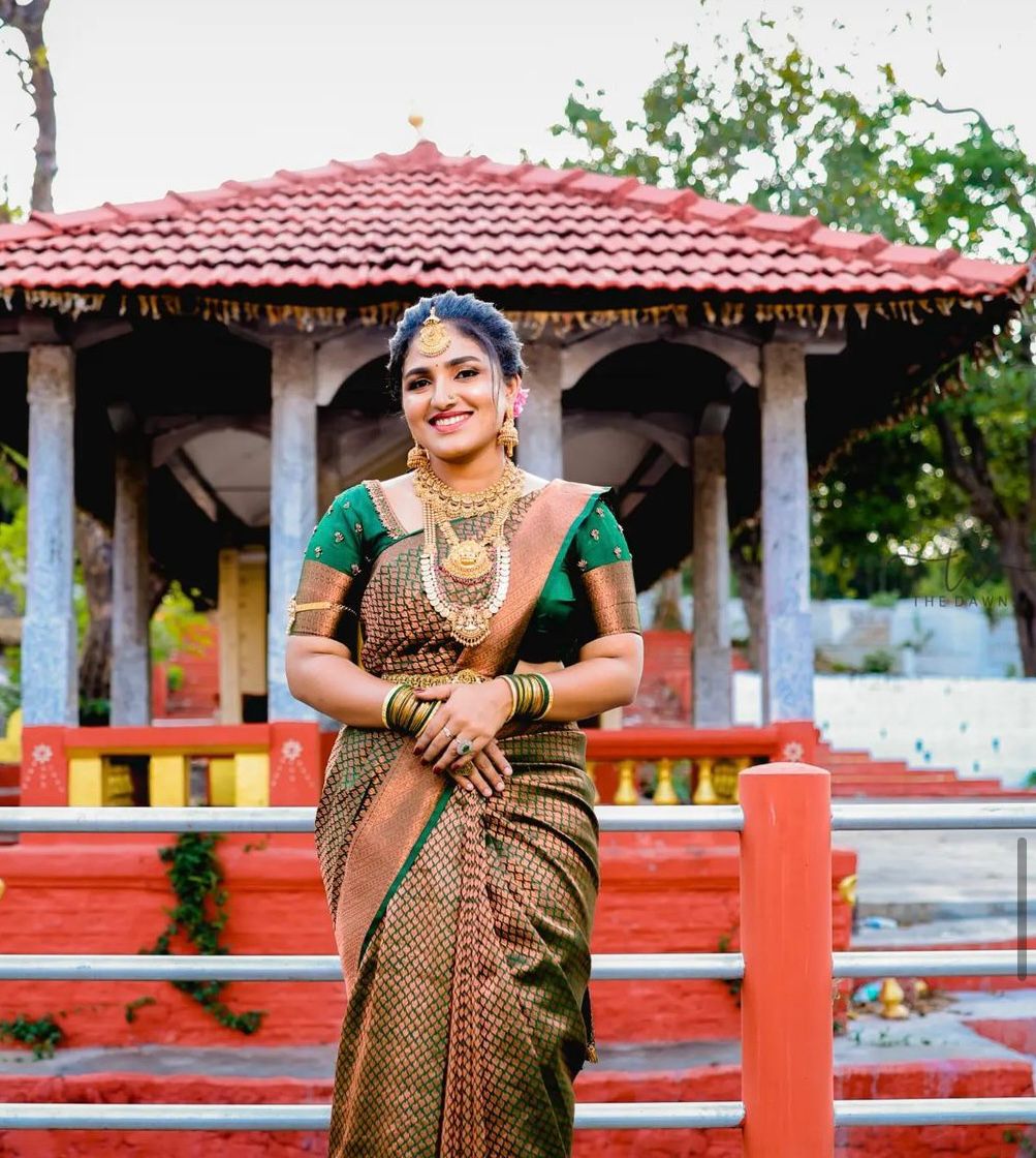 Photo of South indian bride wearing a dark green and purple kanjivaram saree  on her wedding